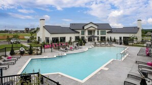 Ein Hotel mit Swimmingpool, Liegestühlen und einem umzäunten Patio-Bereich.