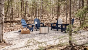 A forested area with outdoor seating including chairs and a fire pit. - Modern Woodsy Cabin, Walk to Sister Bay (Sister Bay)
