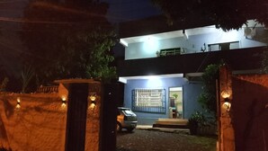 A two-story building with a car parked in front.