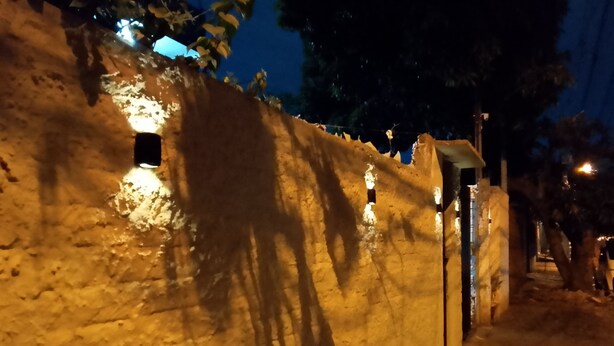 A stone wall with a series of small windows and a gate.