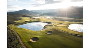 A golf course with multiple ponds and a winding path.