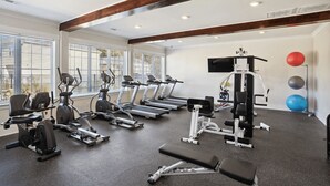 Ein Fitnessstudio mit Laufbändern, Crosstrainern und Gewichten.