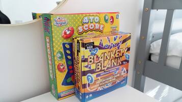 Twee spelletjes, '4 to Score' en 'Blanket Blank', op een wit oppervlak.
