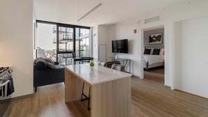 Um apartamento moderno com cozinha espaçosa, sala de jantar e um quarto.
