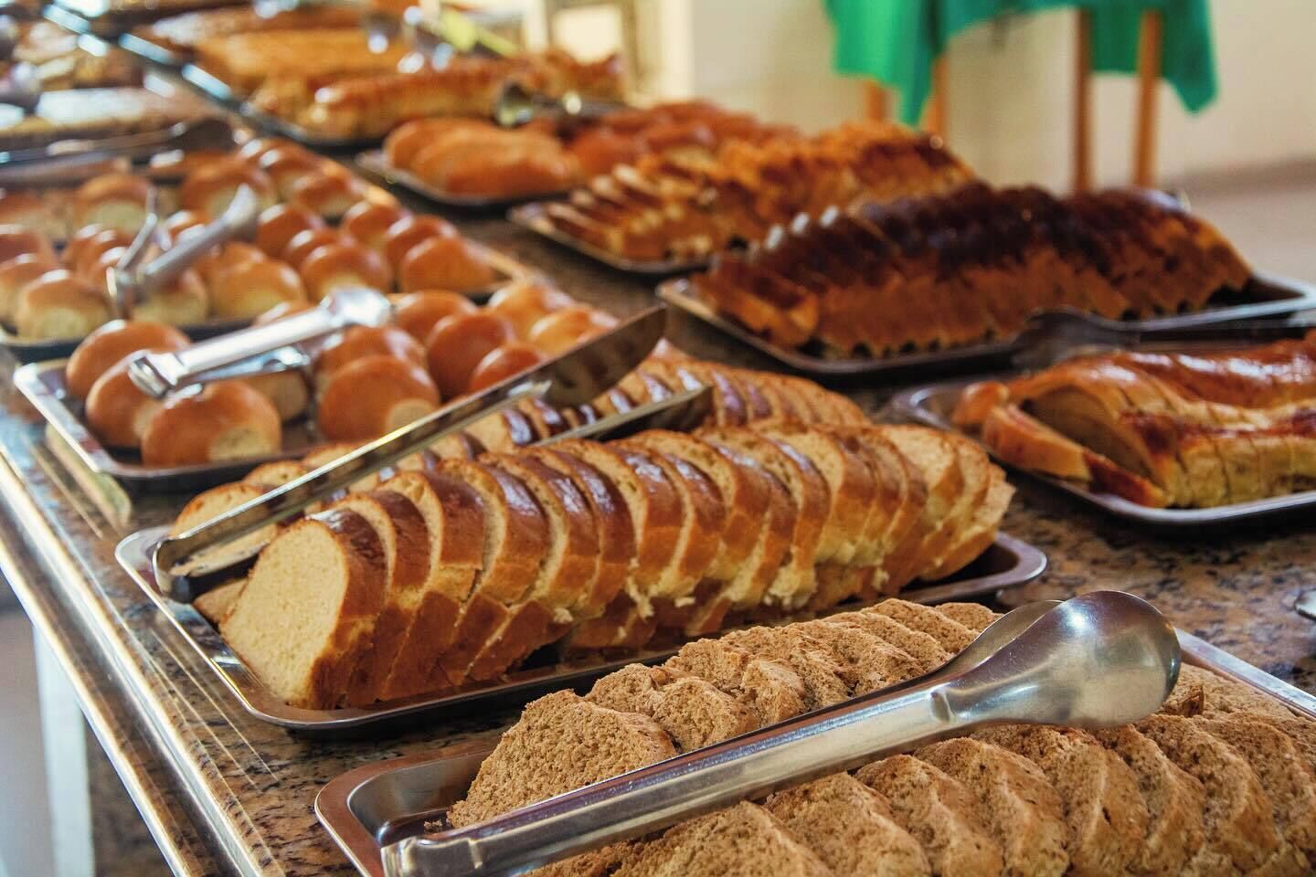 Un buffet proposant une variété de produits de boulangerie, notamment du pain, des petits pains et des viennoiseries.