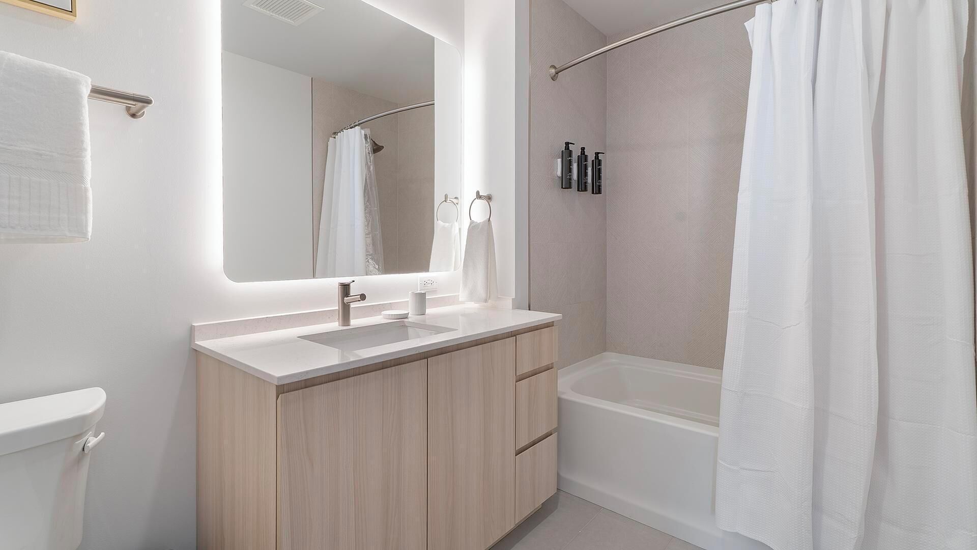 A modern bathroom with a sink, mirror, and shower.