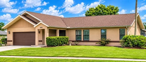 A single-story house with a brown garage, a chimney, and a well-maintained lawn.
