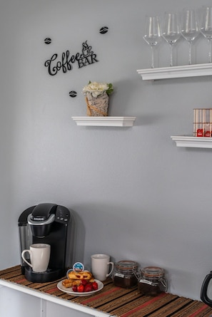 Eine Kaffeestation mit einer Keurig-Kaffeemaschine, einer Auswahl an Gebäck und einer Tasse.