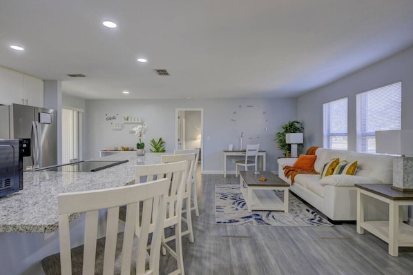 A modern kitchen with granite countertops, white cabinetry, and a built-in oven.