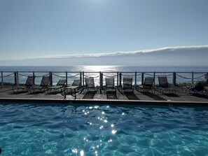 A poolside area with lounge chairs and a view of the ocean. - Whale Watching, Ocean Views, 3 Bedroom Condo in beautiful Depoe Bay - sleeps  8 (Depoe Bay)