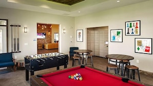 A pool table with balls, a foosball table, and a billiards rack. - Landing | Spectacular 2BD, Game Room, Pool (Spartanburg)