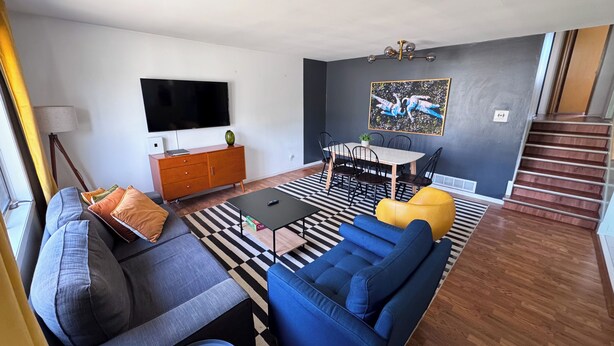 A living room with a sofa, coffee table, and a dining area with chairs and a table. - Sleeps 8 • Pet Friendly • Near Mall of America (Saint Paul)