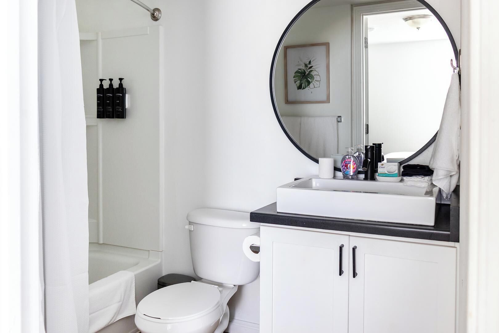 A bathroom with a toilet, sink, and shower.