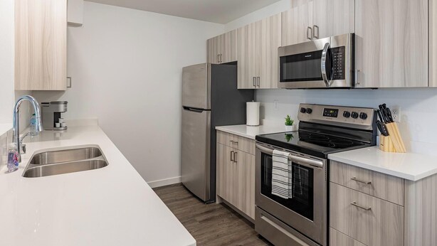 A modern kitchen with stainless steel appliances, a built-in microwave, and a gas stove.