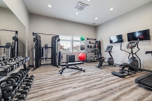 A gym with exercise equipment, a weight rack, and a treadmill.