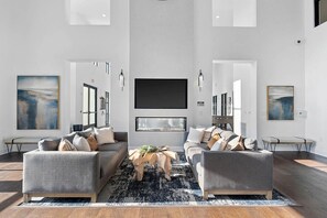 A spacious living room with two sofas, a coffee table, and artwork on the walls. - Landing | Stunning 2BD in Manhattan Harbour (Cincinnati)