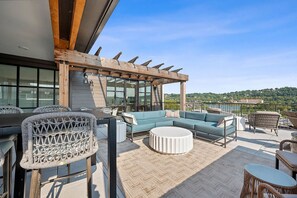 A rooftop terrace with a seating area, a pergola, and a view of the landscape. - Landing | Stunning 2BD in Manhattan Harbour (Cincinnati)