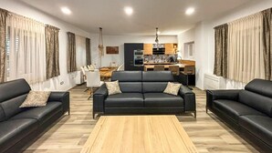 A living room with a sofa set, a coffee table, and a dining area with chairs and a table.