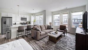 Eine moderne Wohnung mit Küche, Wohnbereich und Balkon.
