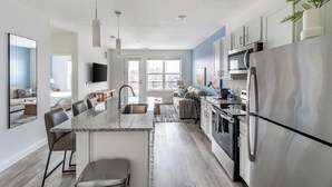 Una cocina moderna con una isla central, electrodomésticos de acero inoxidable y una zona de comedor.