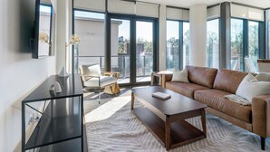 Ein modernes Wohnzimmer mit einer Couch, einem Couchtisch und einem Fernseher.