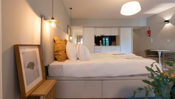 A modern bedroom with a bed, bedside table, and a framed picture. - VIVA Santa Catarina  Serviced Apartments -2 (Porto)