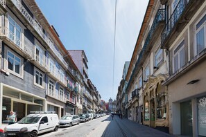 Eine Straße gesäumt von mehrstöckigen Gebäuden, manche mit Balkonen und Schaufenstern.