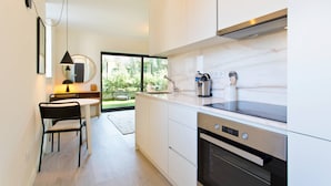 Cocina moderna con armarios blancos, encimera negra y horno empotrado.