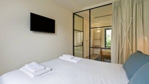 A hotel room with a bed, a flat-screen TV, a sliding glass door, and a view of the outdoors. - VIVA Travessa dos Campos Serviced Apartments D (Porto)