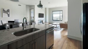 Una cocina moderna con una isla grande, lavavajillas integrado y un comedor con mesa y sillas.