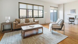Una sala de estar moderna con un sofá, una mesa de centro y un sillón.