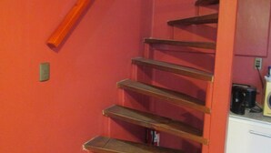 A staircase with wooden steps and a red wall. - B5 Furnished cottage near downtown Puerto Montt (Puerto Montt)