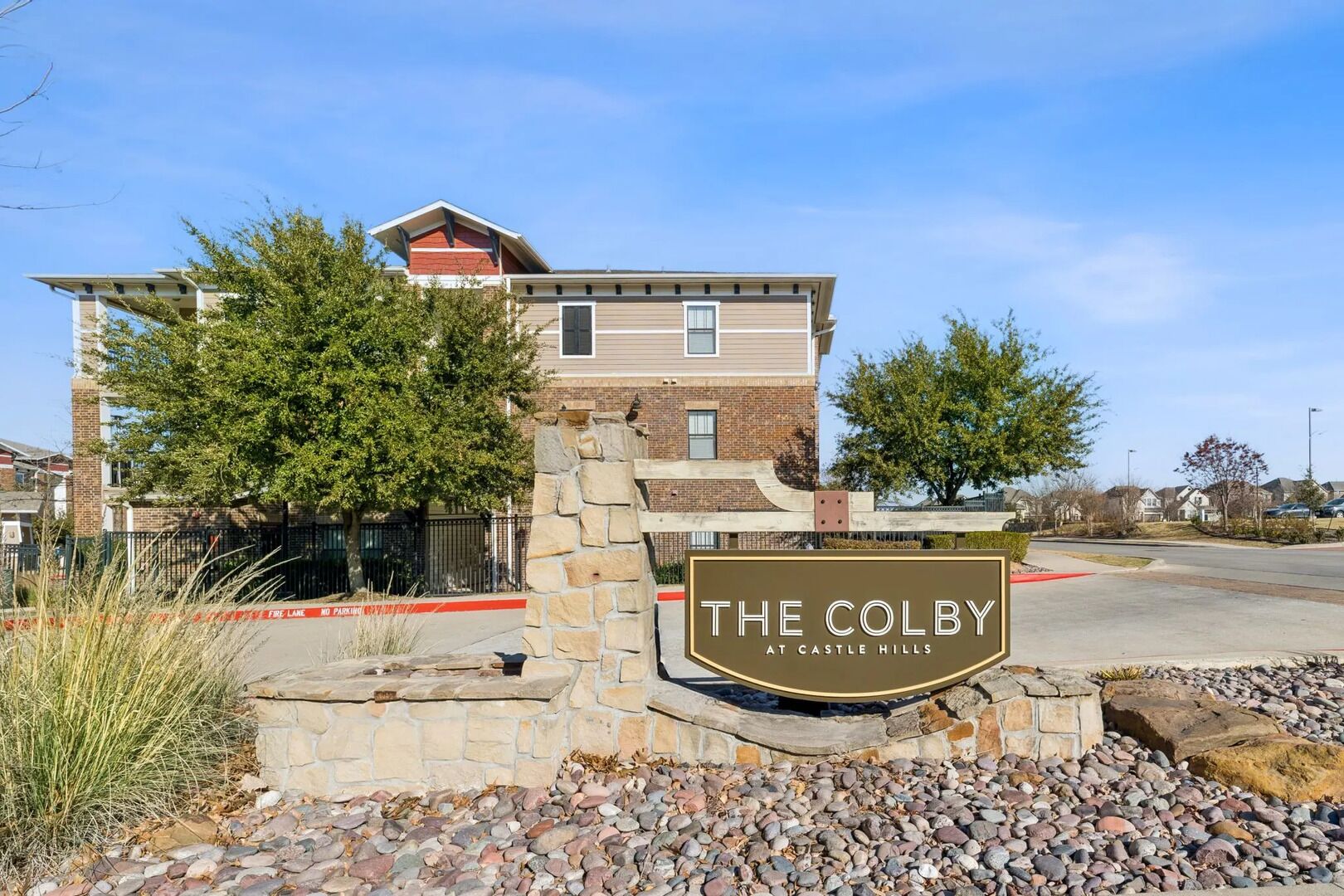 A residential building with a stone entrance and a sign that reads 'THE COLBY AT CASTLE HILLS.'