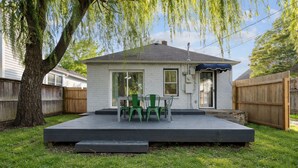 A house with a deck, a covered patio, and a tree. - Adorable 2-bedroom cottage in midtown Tulsa with a dreamy weeping willow. (Tulsa)
