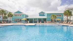 A swimming pool with lounge chairs and umbrellas, surrounded by buildings with a consistent architectural style. - Landing | Spectacular 1BD, Gym, Clubhouse (Rockport)