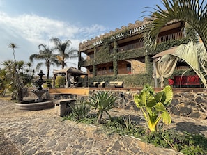 A building with 'DONA JUANA' signage, stone walls, and a stone fountain. - Wellness Petfrendly El Secreto (Tepoztlan)