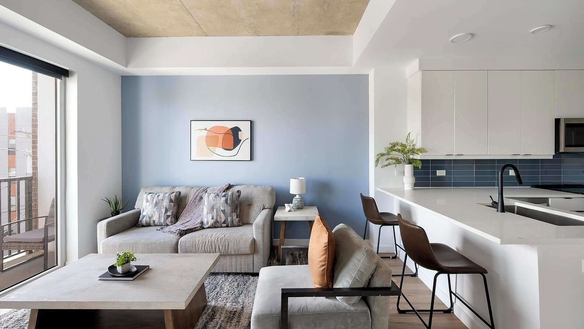 Uma sala moderna com sofá, mesa de centro e área de jantar com cadeiras.