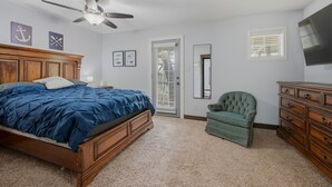 A bedroom with a bed, a chair, a dresser, a ceiling fan, and a door leading to another room. - Peaceful 3-bedroom house with AC in charming Kingston (Kingston)