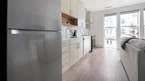 Eine moderne Küche mit weißen Schränken, einem Edelstahlkühlschrank und einem eingebauten Backofen.