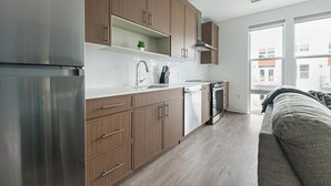 Eine moderne Küche mit Holzausstattung, Edelstahlgeräten und einem Fenster mit Blick auf ein Wohngebiet.