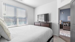 A bedroom with a bed, a dresser, a mirror, and a door leading to another room. - Landing | Amazing 1BD, Clubhouse, Gym (Bessemer)