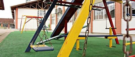 Une aire de jeux avec des balançoires et des structures d’escalade.
