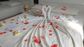 Quarto de hotel com cama bem arrumada, abajur e quadro na parede.