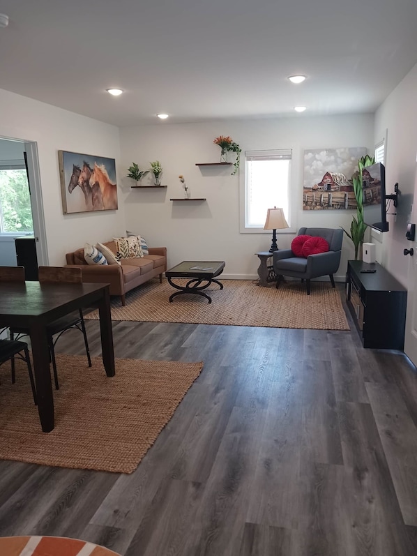 Una sala de estar moderna con un sofá, una mesa de centro y un mueble para la televisión.