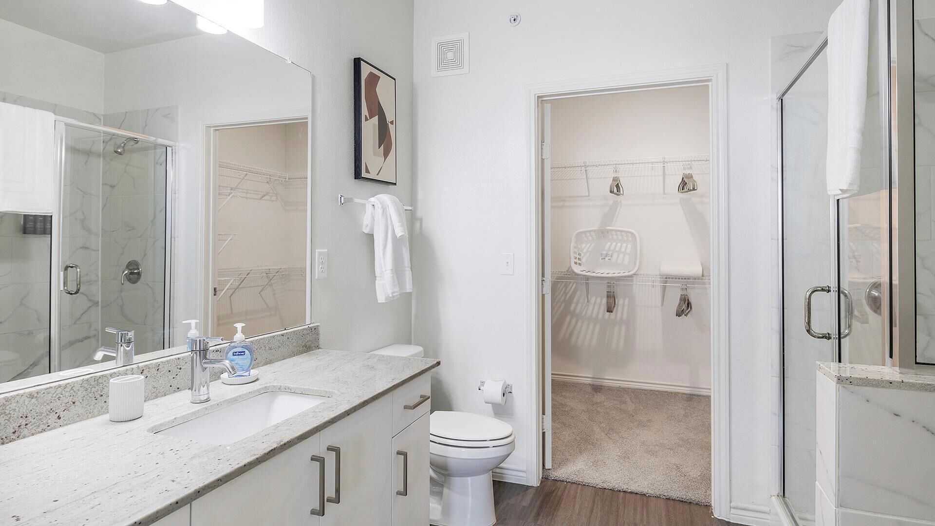A bathroom with a shower, toilet, and sink.