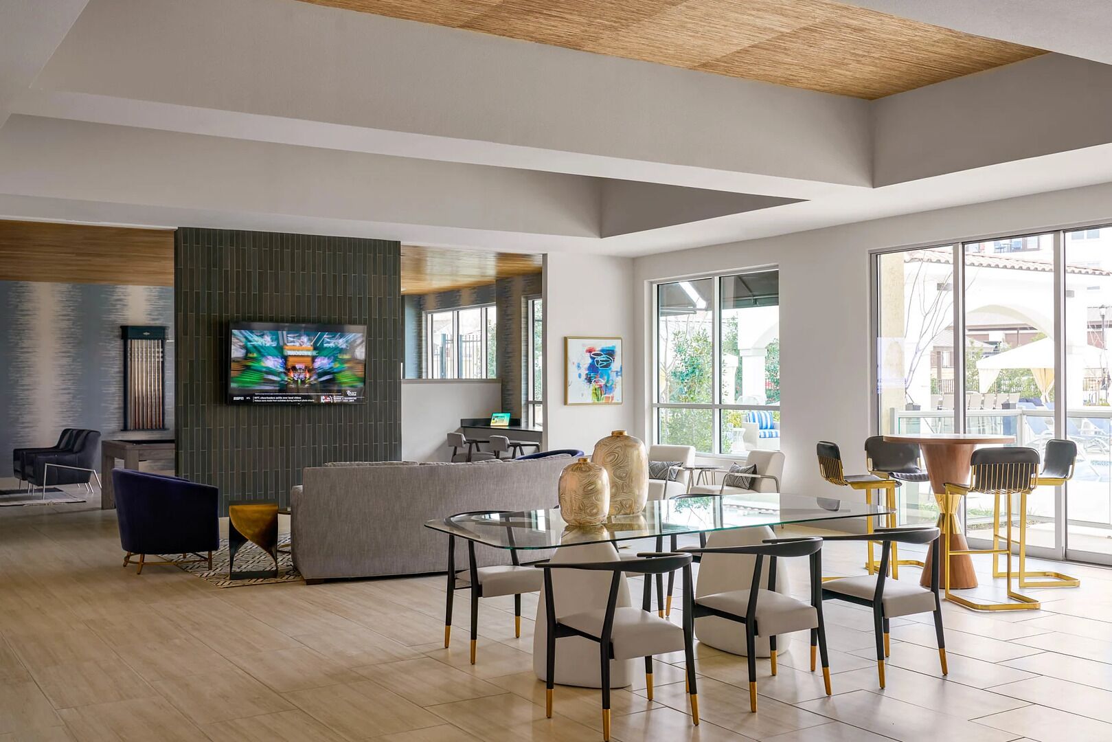 A modern lobby with a reception desk, seating area, and large windows.