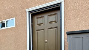 A brown door with a number '3' and a small window above it.