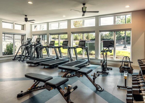 A gym with treadmills, a rowing machine, and weight benches. - Landing | Beautiful 1BD, Clubhouse, Pool (Nashville)