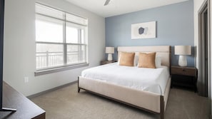 A bedroom with a large window, a bed with two pillows, two bedside tables with lamps, and a wall-mounted artwork. - Landing | Modern 1BD, Clubhouse, Pool (Nashville)