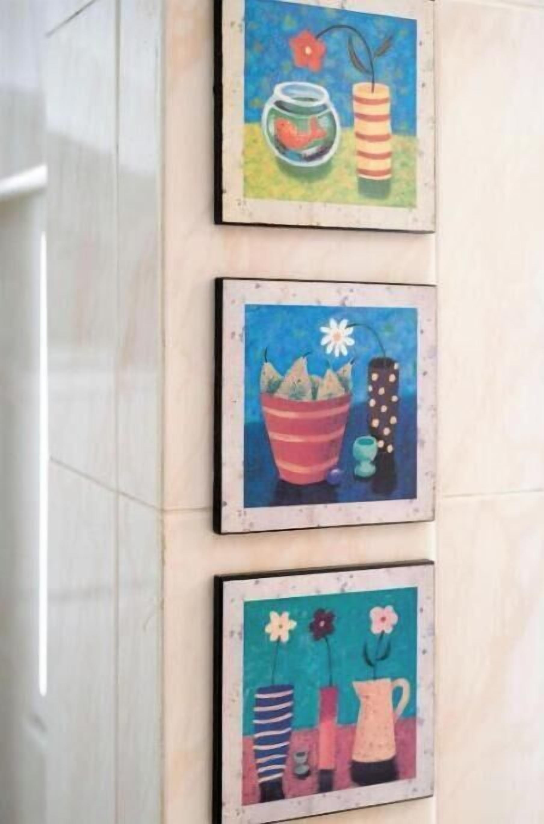 Een muur met drie ingelijste kunstwerken die verschillende planten en bloemen afbeelden.